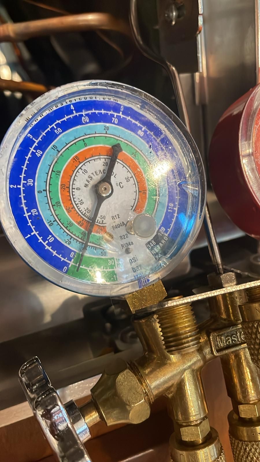 Refrigerant gauges connected during a refrigerator sealed-system diagnosis